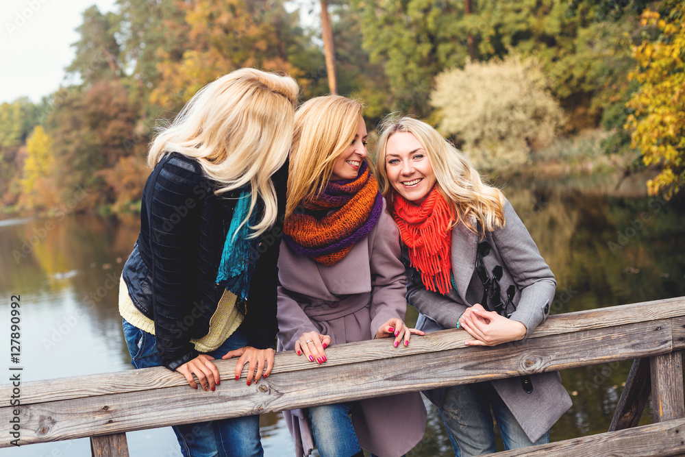 Happy friends having fun in beautiful autumn park. Pretty women in fall time Happy friends having fun in beautiful autumn park. Pretty women in fall time