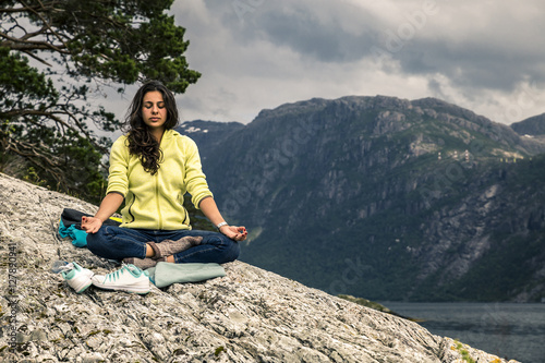 Young woman is taking a rest on the island in the fjord  Norway