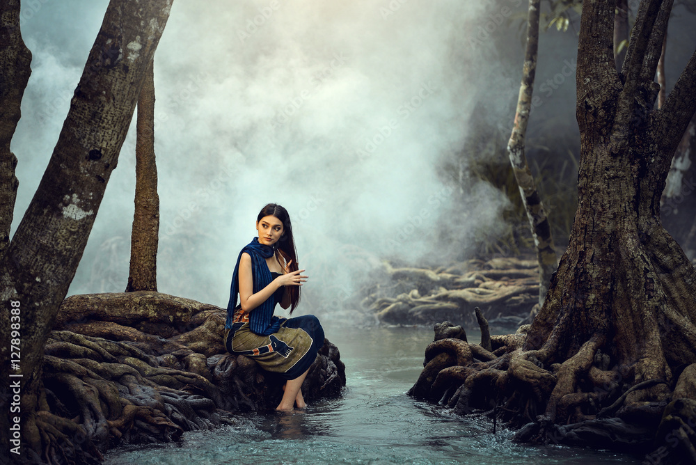 Fototapeta premium Asian woman wearing traditional thai take a baht on during sunset at river,vintage style,Beutiful woman take a baht in river,woman wearing thai culture