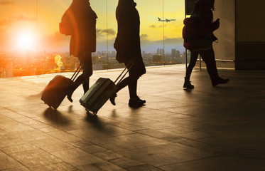 people and traveling luggage walking in airport terminal buildin