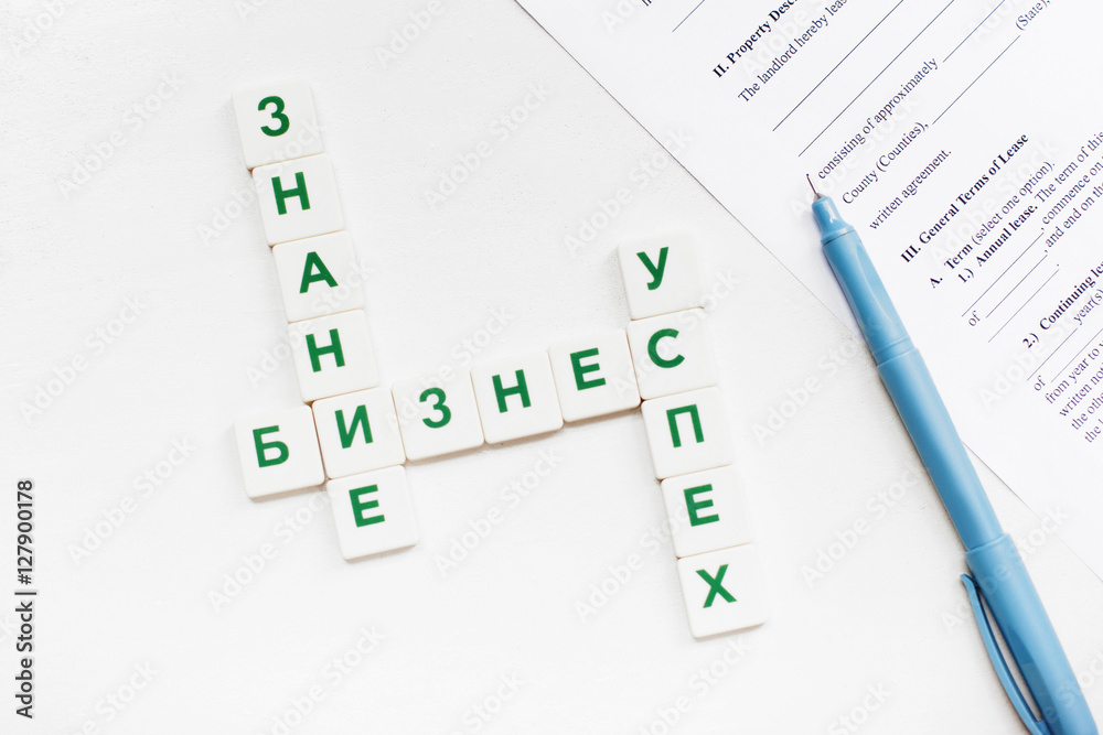 Russian scrabble words on business concept with pen and contract paper. Featured words are: Knowledge, Business, Success. Isolated with free space Russian scrabble words on business concept with pen and contract paper. Featured words are: Knowledge, Business, Success. Isolated with free space
