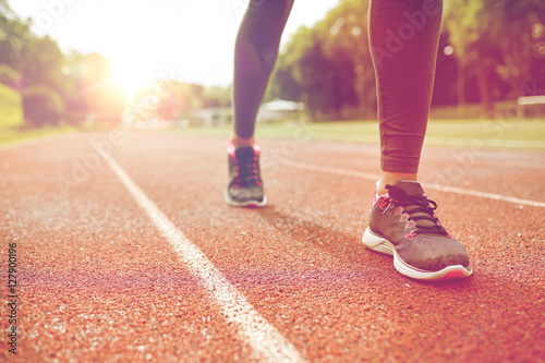 close up of woman feet running on track from back