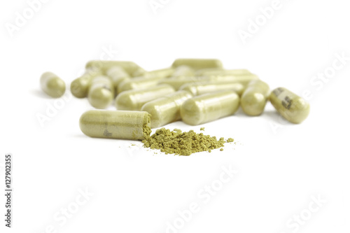 green capsule pills on white background