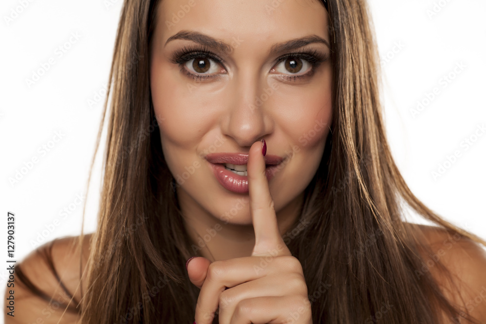 young woman with a finger to her lips. concept for silence young woman with a finger to her lips. concept for silence