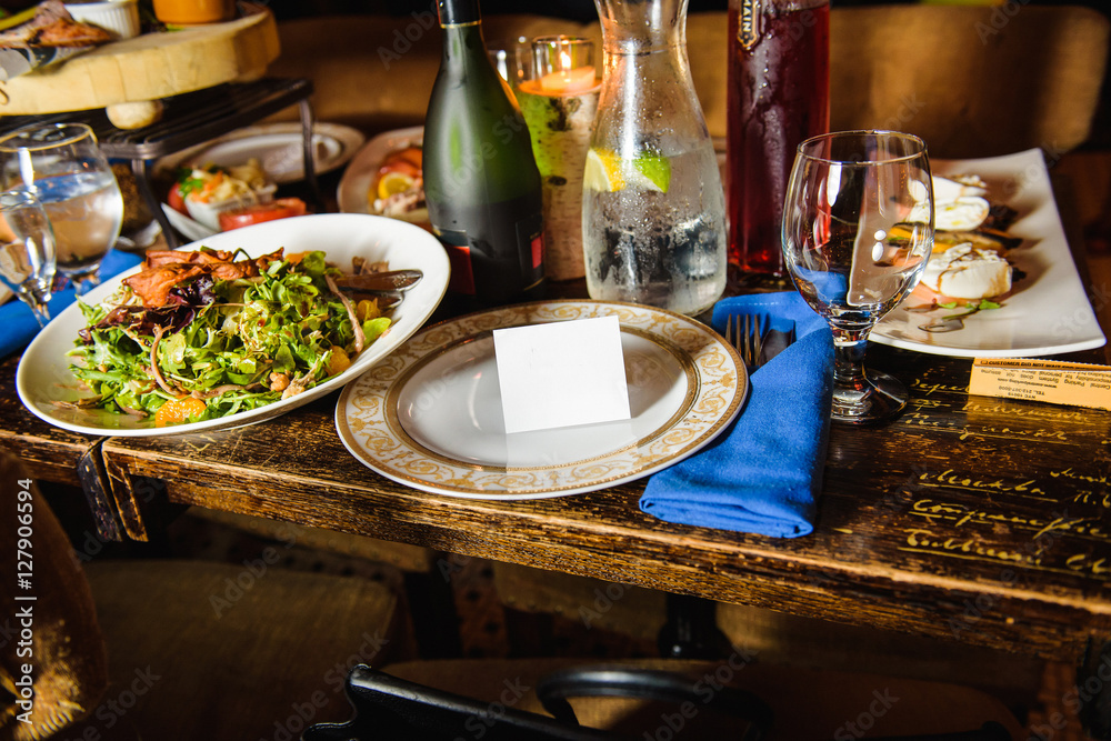 White card stands on dinner plate with golden ornament