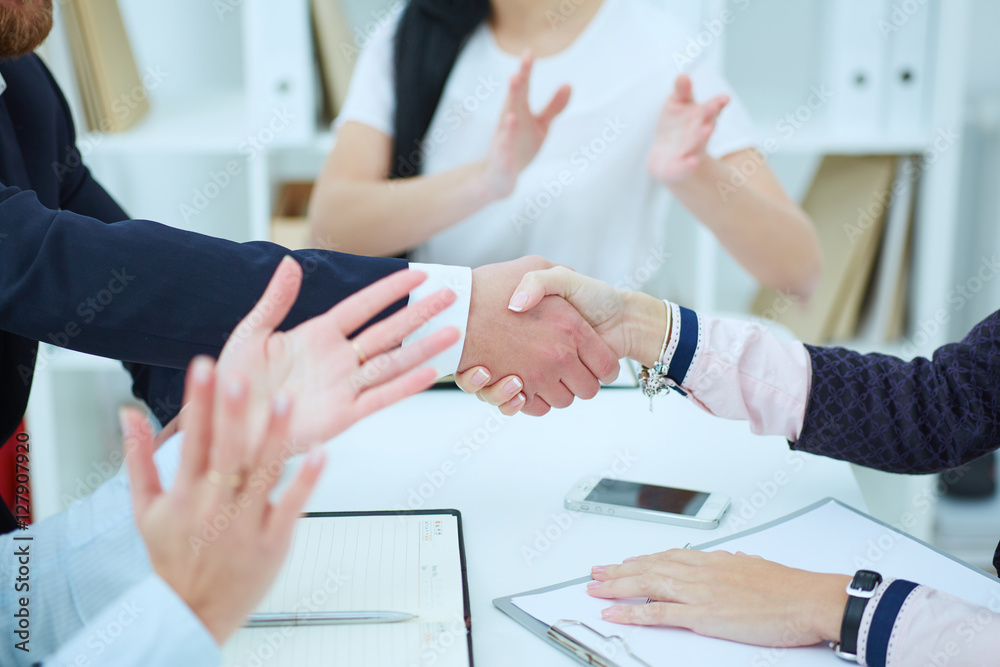 Male and female handshake in office. Serious business and partnership concept. Partners made deal, sealed with handclasp.