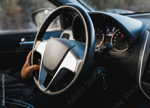 hand on steering wheel close up of a man driving a car