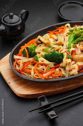 Asia food. Udon noodles with vegetables on a black table photo