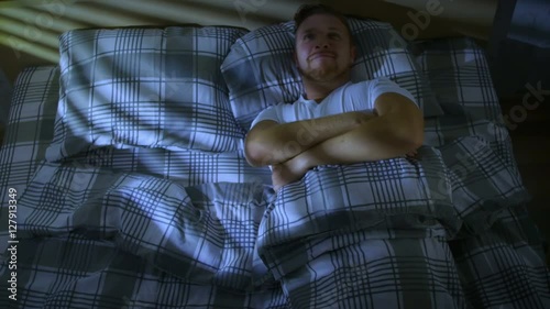 The man lies in a bed and dreams of tomorrow