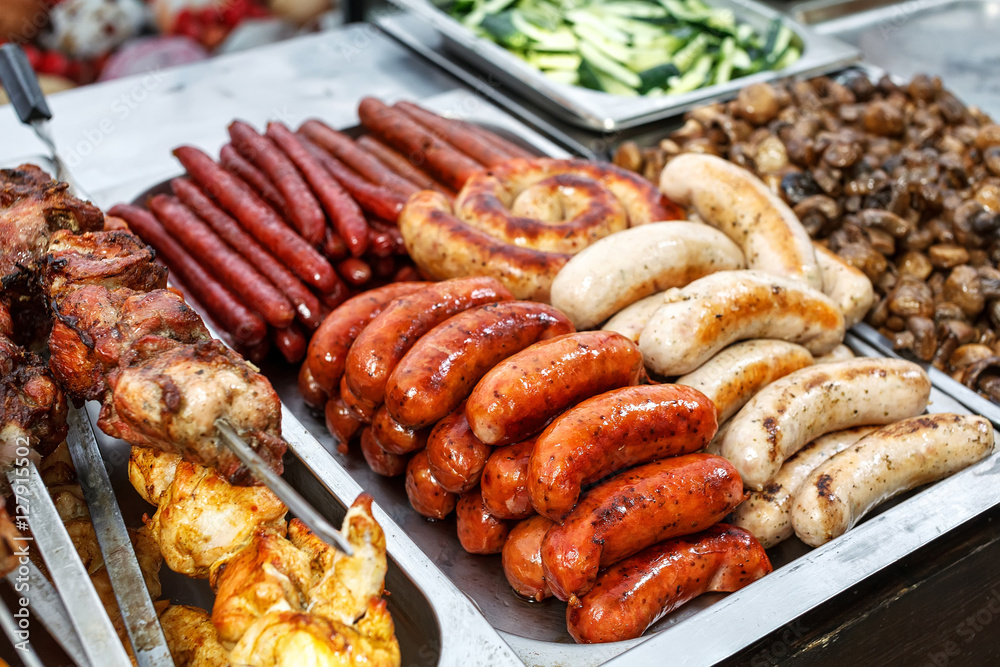 Assorted German sausages grilled in a steel container