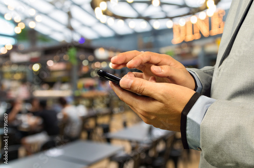 Man using Smartphone or Cellphone in café or Restaurant