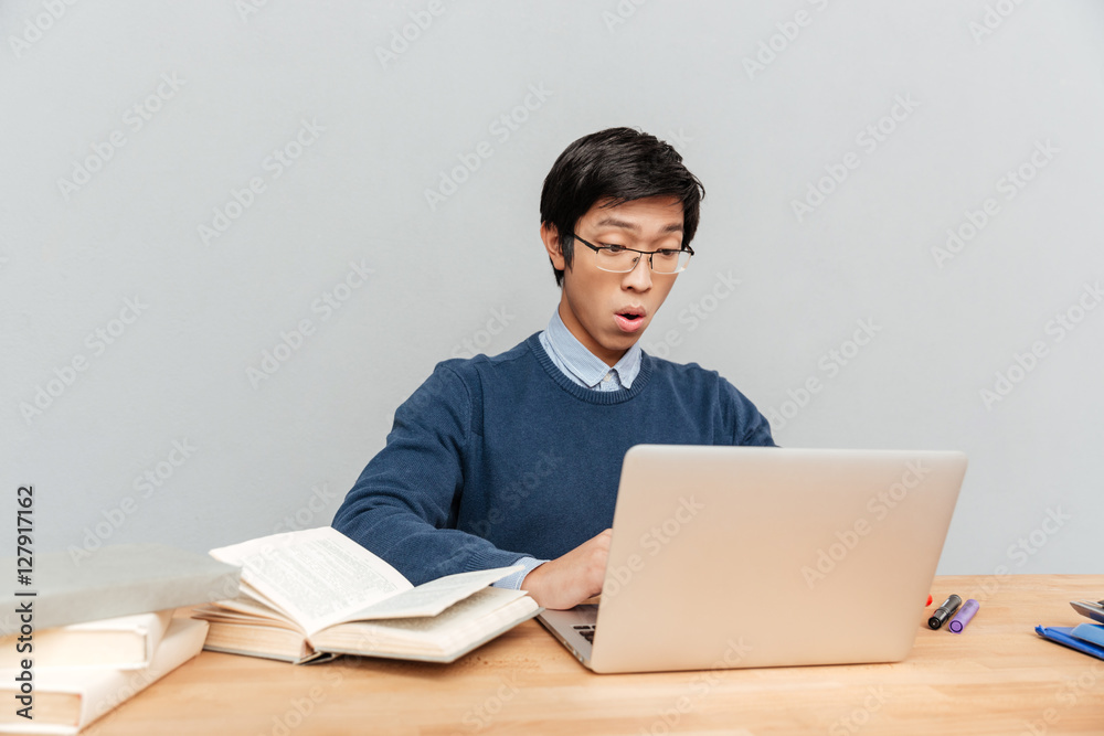Asian student sits by the table Asian student sits by the table