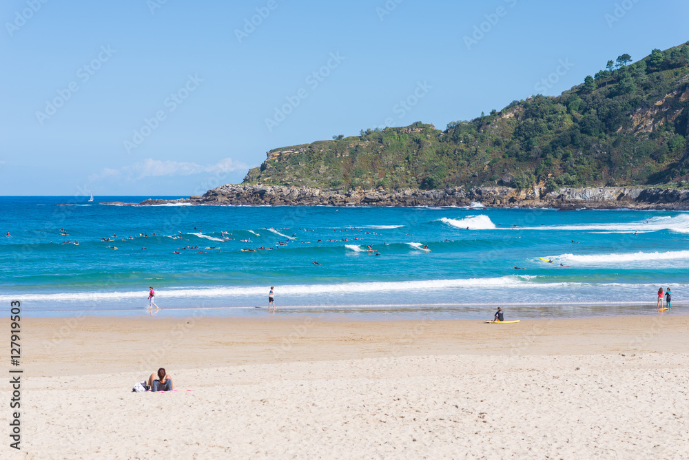 Surfer do water sport, people relax at the beach La Zurriola in Donostia San Sebastian. The beach is situated at the district Gros of San Sebastian. The beach is famous for surfing,sports and relaxing
