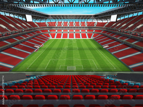 Large soccer-football stadium with roof and red chairs