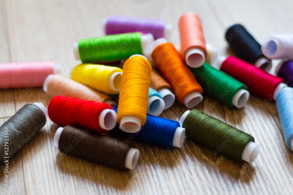 multicolored bobbin of thread on a wooden background
multicolored bobbin of thread on a wooden background