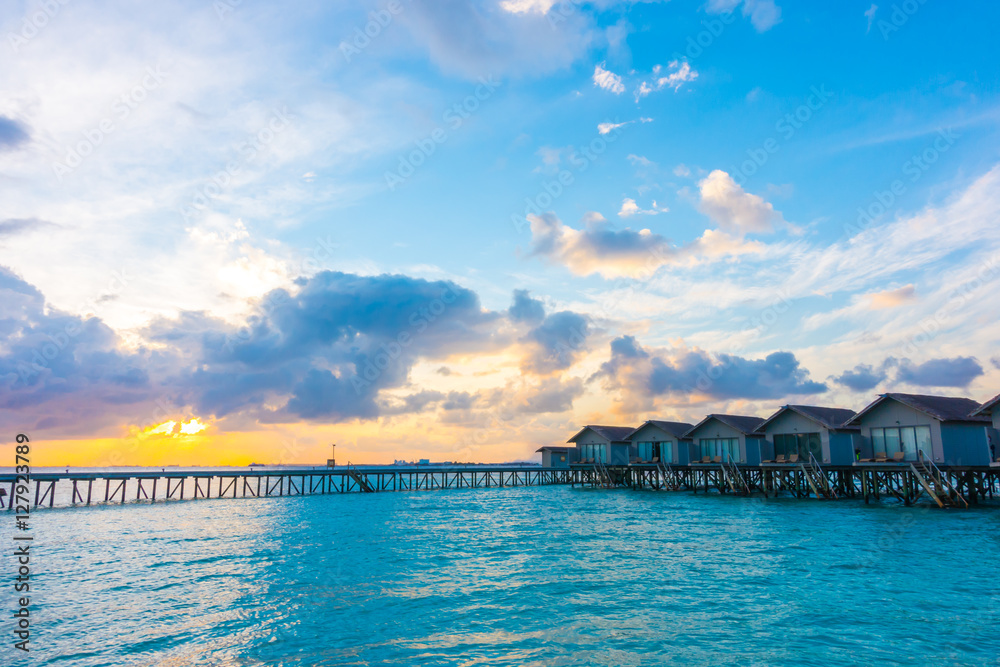 Beautiful sunrise with  water villas  in tropical Maldives islan