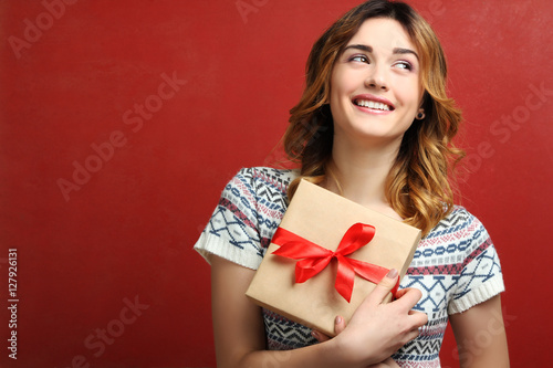 Portrait of a happy girl with a gift box in hands.