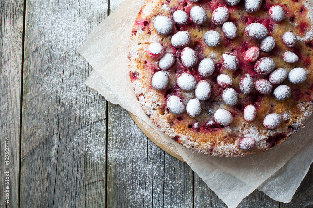 Homemade cranberry pie with walnuts, berries and powdered sugar. Top view. Space for text. Rustic style. Selective focus. Homemade cranberry pie with walnuts, berries and powdered sugar. Top view. Space for text. Rustic style. Selective focus.