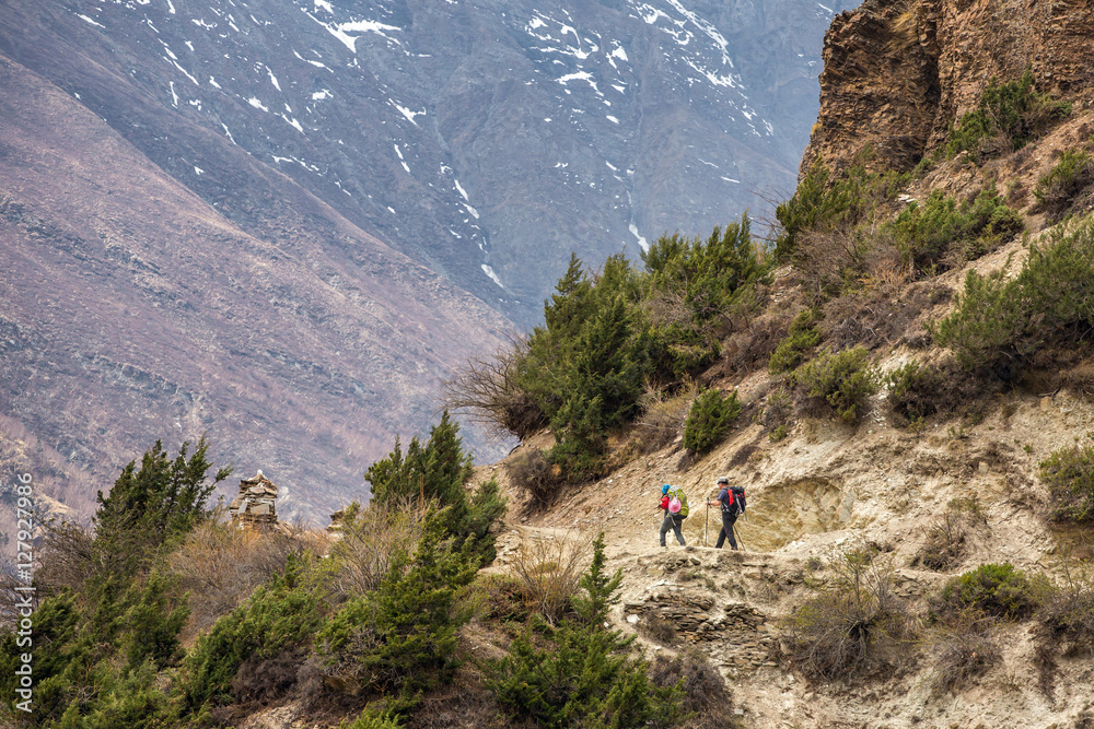 Beautiful mountain landscape with two hikers with backpacks on A