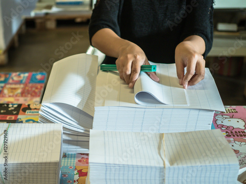 Asian women fold a piece of paper to ready to make a books in bo
