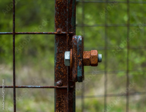 The old and rusty lock on a metal gate.