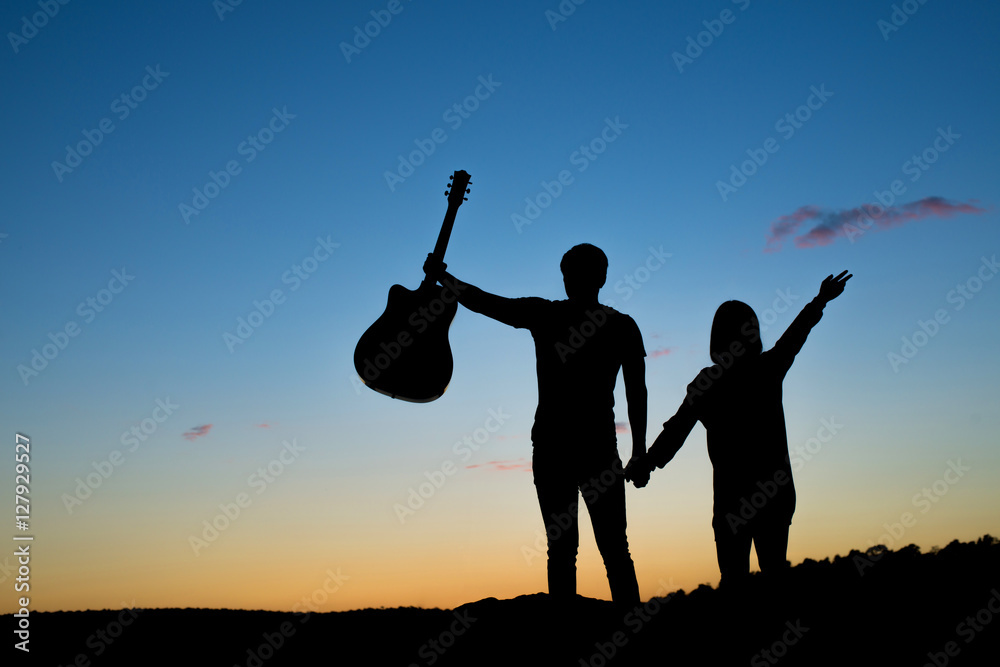 silhouette of musician with guitar and couple love holding hand at sunset  field, music background Stock Photo | Adobe Stock