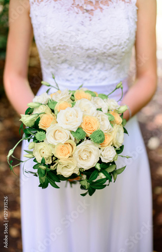 beautiful and delicate wedding bouquet in hands of the bride