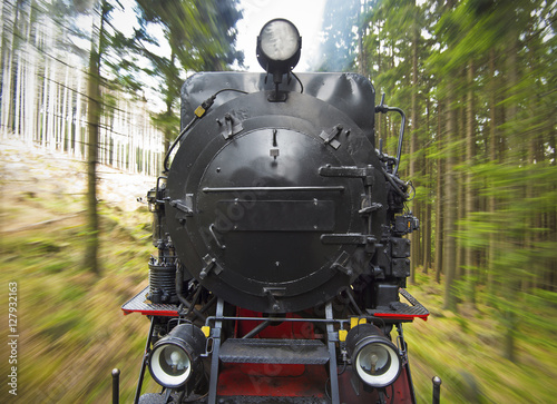 front view of a historic German black steam powered railway train in motion blur, National Park Harz, Germany