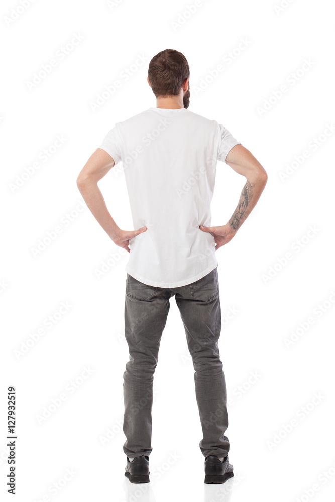 Foto Stock Back pose, full length shot of a young man looks ahead isolated  | Adobe Stock