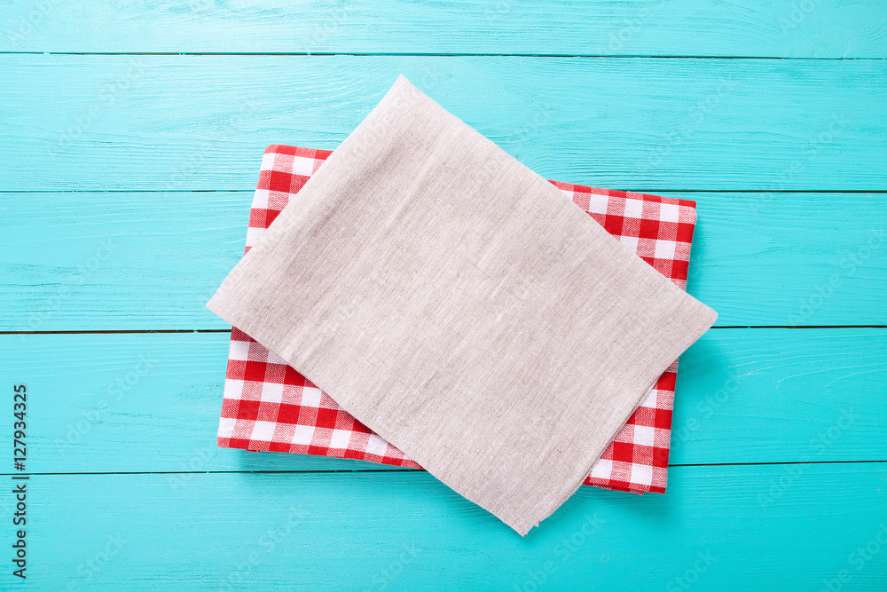 Red plaid tablecloth and gray one on blue wooden table. Top view and copy space Red plaid tablecloth and gray one on blue wooden table. Top view and copy space