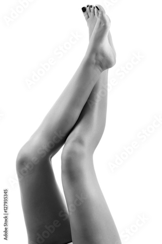 Beautiful woman legs on a black and white . Body care.