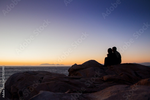 Couple sitting watching sunset