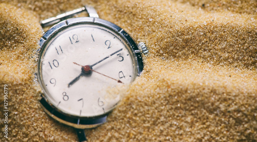 Old watch buried in sand