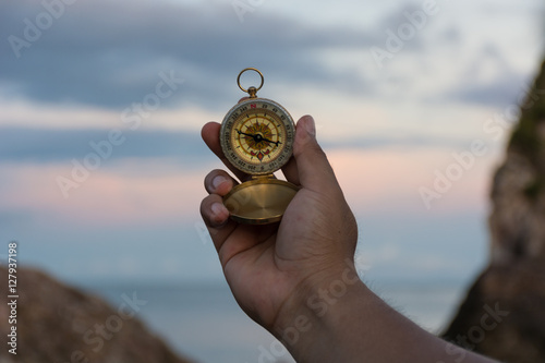 Compass in the hand on the nature background