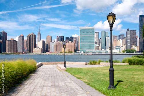 The midtown Manhattan skyline on a summer day seen from a beautiful park in Queens