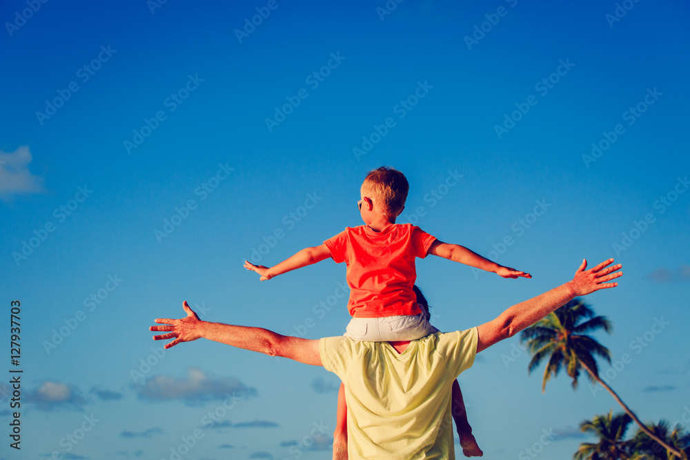 happy father and little son on shoulders play at sky happy father and little son on shoulders play at sky