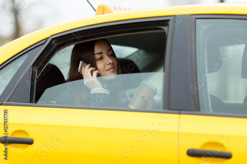 Woman sitting in yellow taxi