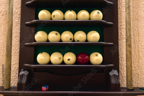 Universal rack of billiard balls and cues. photo