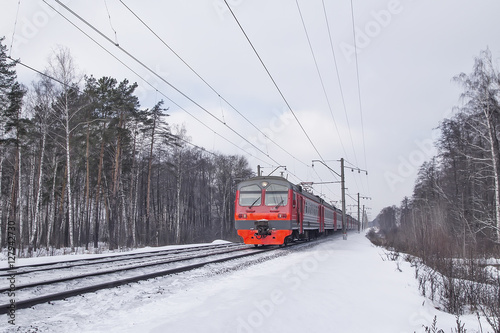 train rides through forest path in winter railway