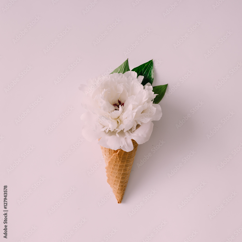 Fototapeta Icecream cone with white flower and leaves.
