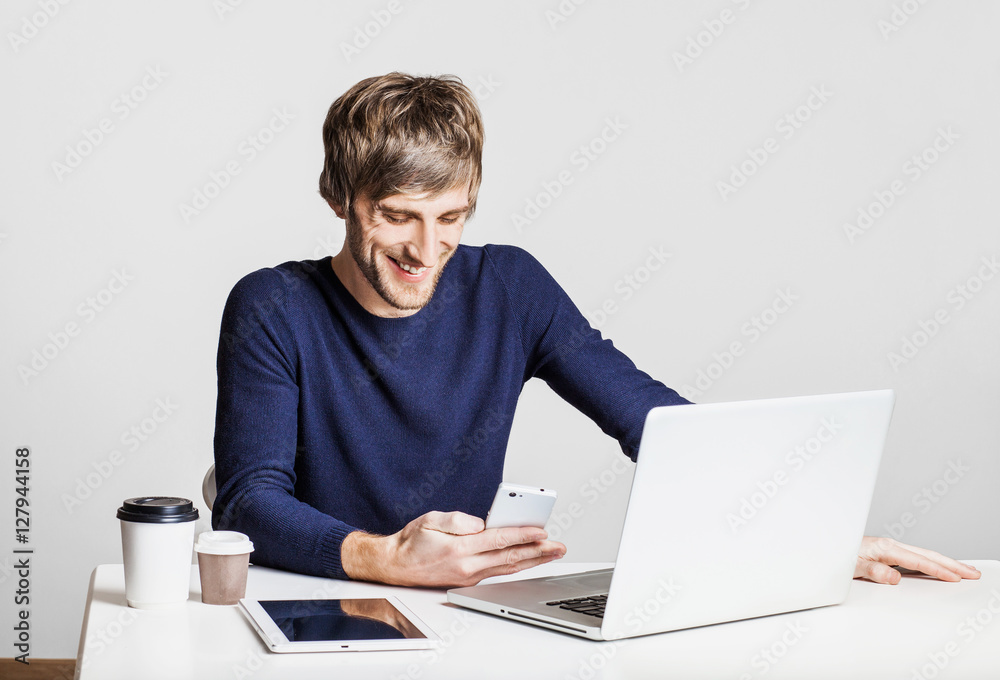 Portrait of a young happy business man working with laptop computer and using smart phone Portrait of a young happy business man working with laptop computer and using smart phone