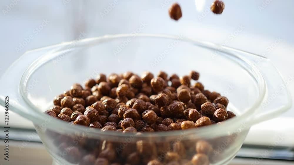 Corn balls with chocolate flavor slowly falling into a bowl. Slow Motion Corn balls with chocolate flavor slowly falling into a bowl. Slow Motion