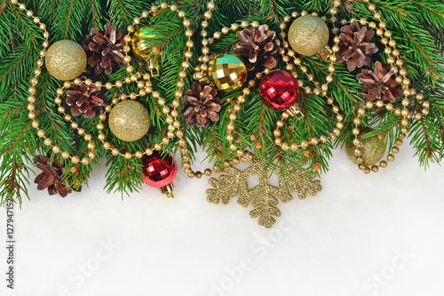 Christmas decorations and spruce branch and cones on a white