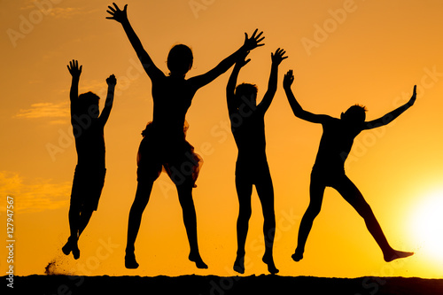 silhouette of four jumping kids against sunset