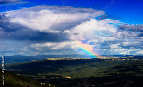 Rainbow in Norway mountains landscape background