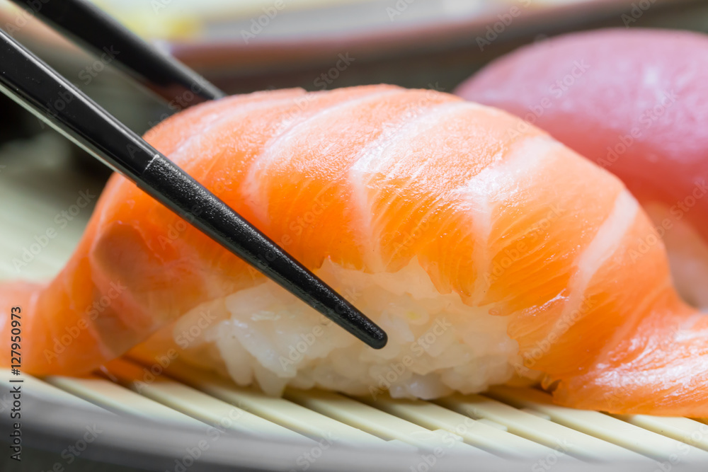 Salmon sushi with chopsticks black Salmon sushi with chopsticks black