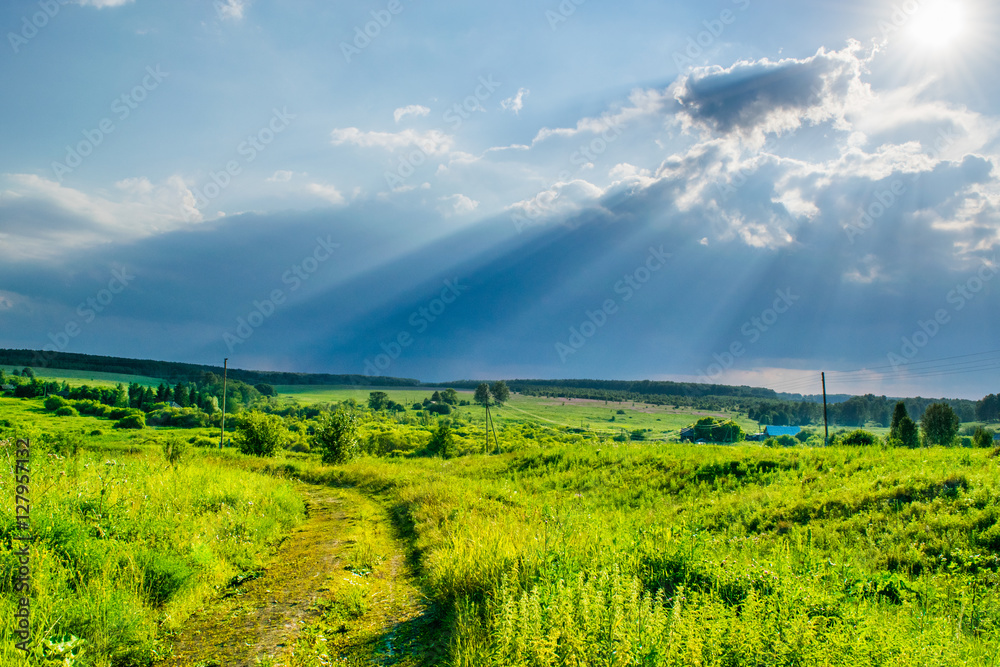 Sun rays at storm sky under a valley