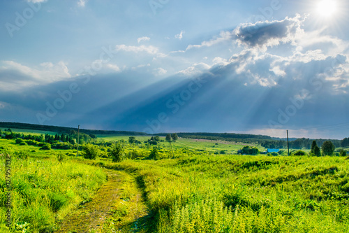 Obraz na płótnie Sun rays at storm sky under a valley w salonie