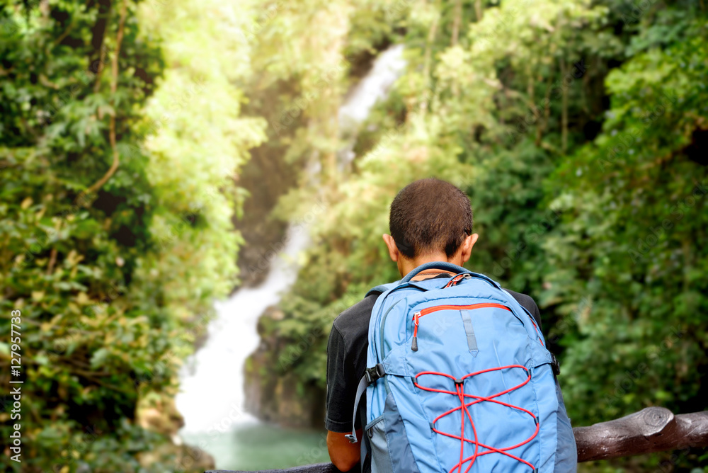 Middle age man backpacker enjoying mountain trip.Traveler Asian man trekking in rain forest and watching waterfall with backpack in summer trip vacation outdoor.Namtok Phliu National Park,Chanthaburi Middle age man backpacker enjoying mountain trip.Traveler Asian man trekking in rain forest and watching waterfall with backpack in summer trip vacation outdoor.Namtok Phliu National Park,Chanthaburi