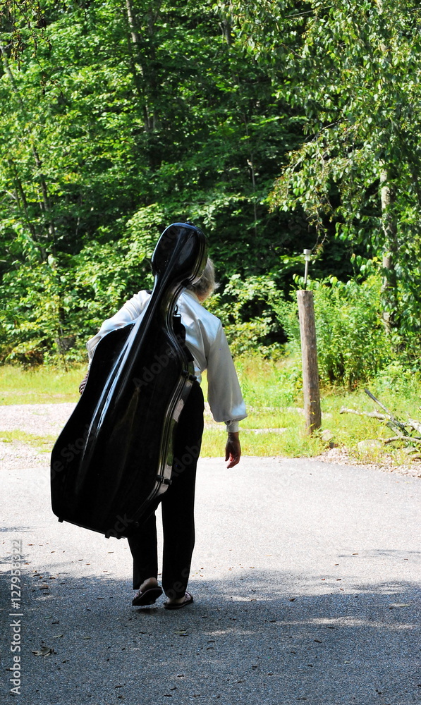 Female musician walking home with her cello. Female musician walking home with her cello.